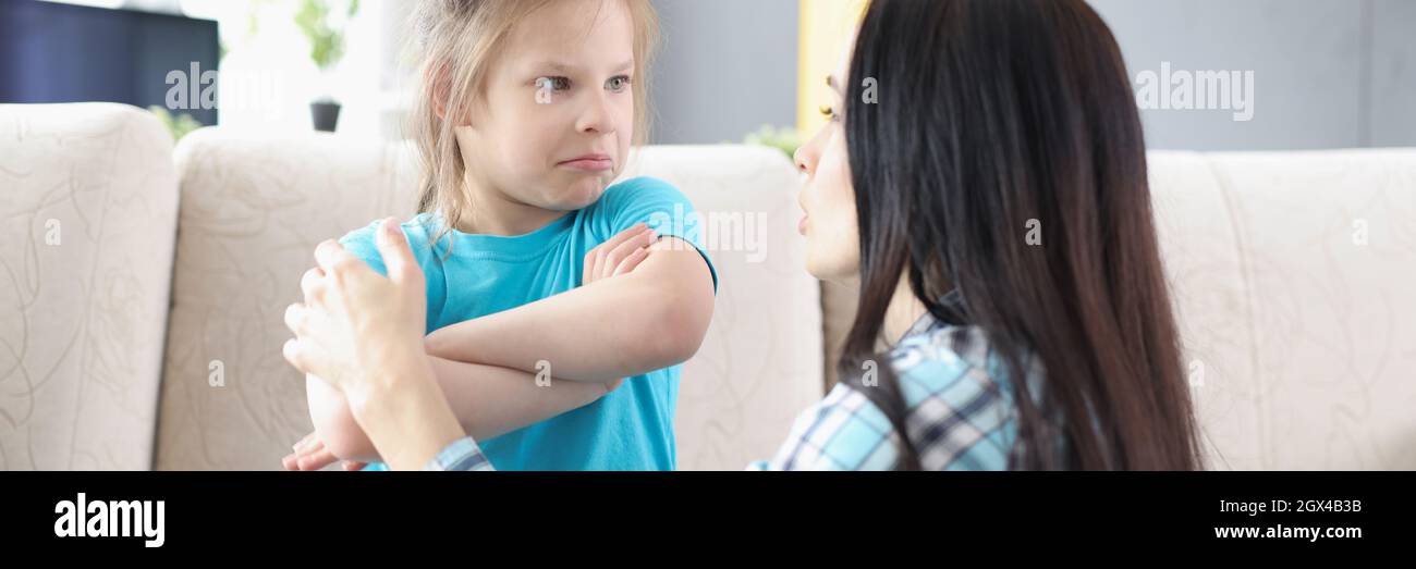 Traurige beleidigte Tochter, die auf der Couch saß und sich nach dem Streit zu Hause zur Mutter zurückwandte Stockfoto