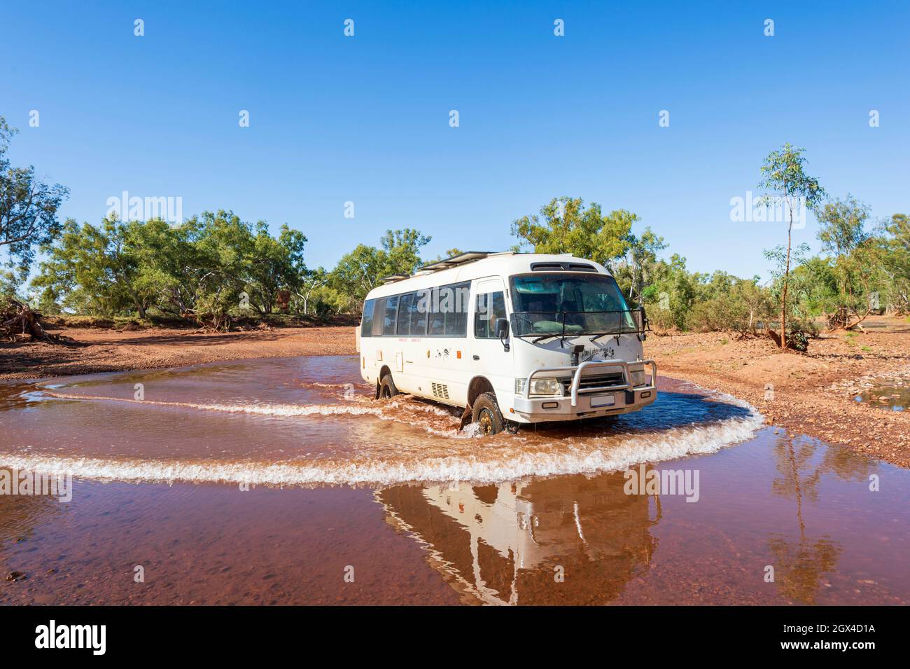 Toyota Coaster-Wohnmobil mit Allradantrieb über einen Bach in Pilbara, Western Australia, Australien Stockfoto