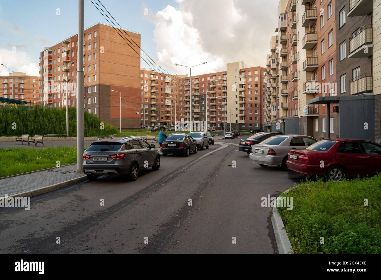 An einem Sommertag werden Autos im Hof von Mehrfamilienhäusern im Stadtteil Yasny geparkt. Stockfoto