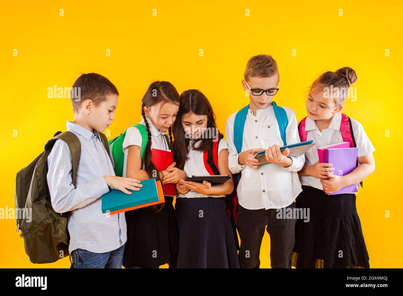 Gruppe von Klassenkameraden, die Bücher und E-Books lesen Stockfoto