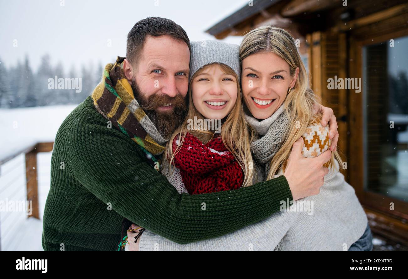Porträt der Familie mit kleiner Tochter im Freien in Winterferienhaus, Blick auf die Kamera. Stockfoto
