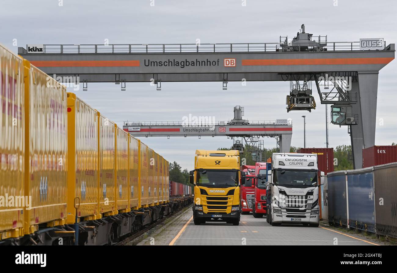 04. Oktober 2021, Brandenburg, Großbeeren: An einer Verladestation am DUSS-Terminal werden Container von der Straße auf die Schiene oder umgekehrt verladen. Der Logistikkonzern Deutsche Post DHL Group und die Deutsche Bahn AG bauen ihre bestehende Zusammenarbeit im Bereich des Paketverkehrs auf der Schiene aus. Damit soll der Anteil der per Bahn transportierten DHL-Pakete von 2 auf 6 Prozent steigen. Neue Strecken sollen auch dem bestehenden Schienennetz für Pakete hinzugefügt werden. Foto: Patrick Pleul/dpa-Zentralbild/dpa Stockfoto