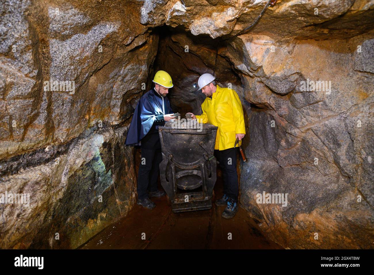04. Oktober 2021, Sachsen, Zinnwald: Der sächsische Wirtschaftsminister Martin Durig (SPD, l) hört Thomas Dittrich, Geologe bei der Deutschen Lithium GmbH, auf der Besuchermine "vereinigt Zwitterfeld zu Zinnwald" auf eine Jagd beim "Rohstofftag", um lithiumreiches Erz zu erklären. Um sich einen Eindruck von Sachsens Anteil an der zukünftigen Rohstoffgewinnung zu verschaffen, besucht der Wirtschaftsminister verschiedene Akteure. Foto: Robert Michael/dpa Stockfoto