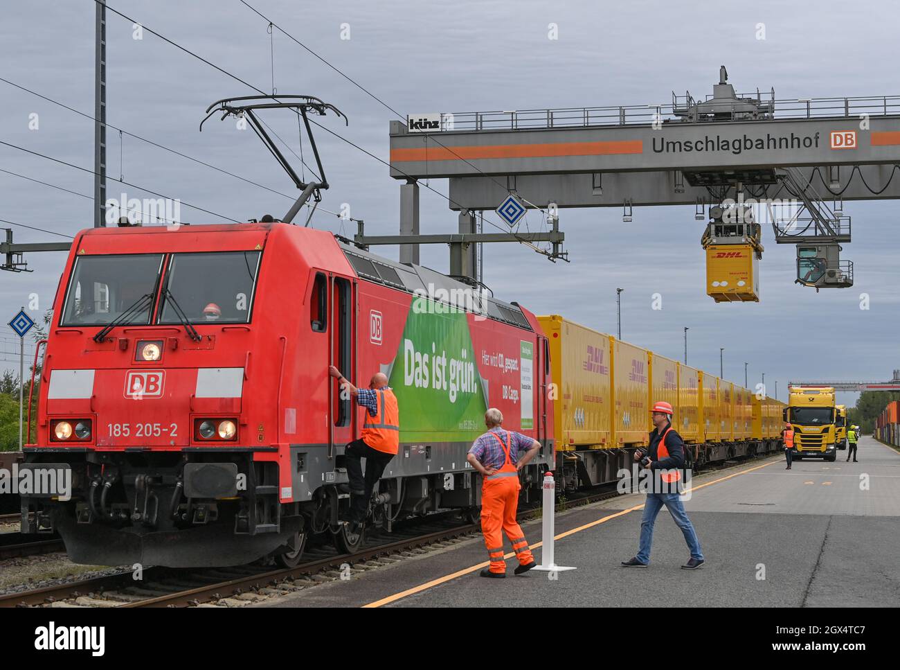 04. Oktober 2021, Brandenburg, Großbeeren: An einer Verladestation am DUSS-Terminal wird ein DHL-Container der Deutschen Post von einem LKW auf einen Wagen der Deutschen Bahn gehoben. Der Logistikkonzern Deutsche Post DHL Group und die Deutsche Bahn AG bauen ihre bestehende Zusammenarbeit im Bereich des Paketverkehrs auf der Schiene aus. Damit soll der Anteil der per Bahn transportierten DHL-Pakete von 2 auf 6 Prozent steigen. Neue Strecken sollen auch dem bestehenden Schienennetz für Pakete hinzugefügt werden. Foto: Patrick Pleul/dpa-Zentralbild/dpa Stockfoto