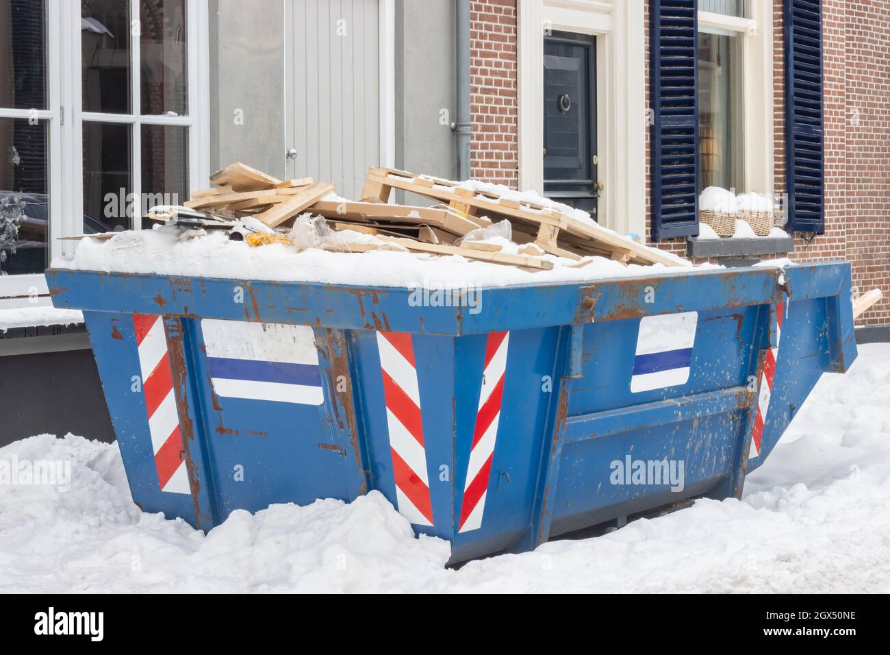 Holländischer Abfallcontainer in einer alten Straße auf einer Hausrenovierungsstelle im Winter Stockfoto