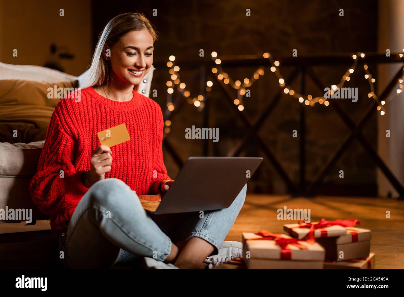 Weihnachtsgeschäfte. Lächelnde Dame mit Laptop und Kreditkarte Stockfoto