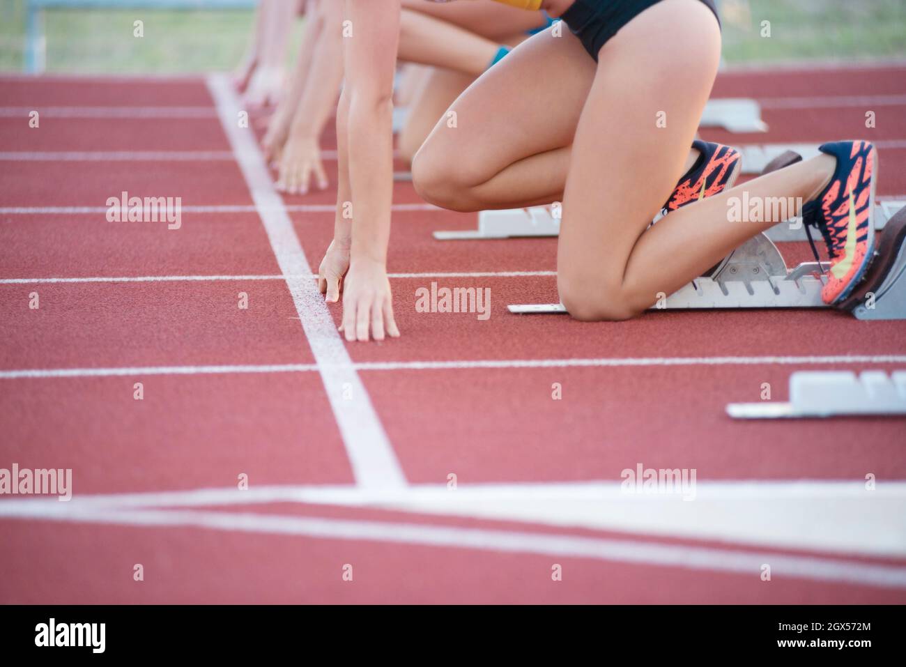 Eine Gruppe weiblicher Leichtathleten auf Startblöcken Stockfoto