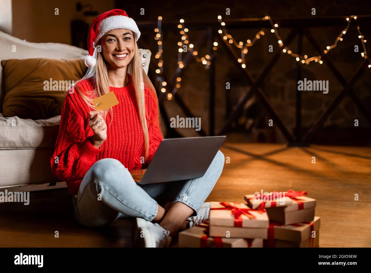 Weihnachtsgeschäfte. Lächelnde Frau mit Laptop und Kreditkarte Stockfoto