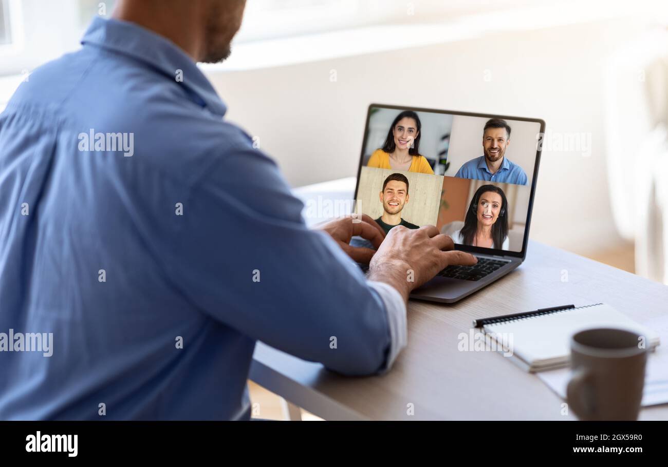 Der ausgeschnittene Tausendjährige Kaukasianer hat am Arbeitsplatz Online-Meetings mit verschiedenen Mitarbeitern auf dem Laptop-Bildschirm Stockfoto