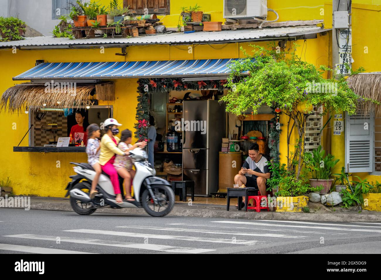 Traditionelles vietnamesisches Café mit einer Terrasse am Straßenrand, dekoriert mit Blumen. Die Besucher verbringen Zeit im Restaurant. Nha Trang, Vietnam: 2020-10-23 Stockfoto