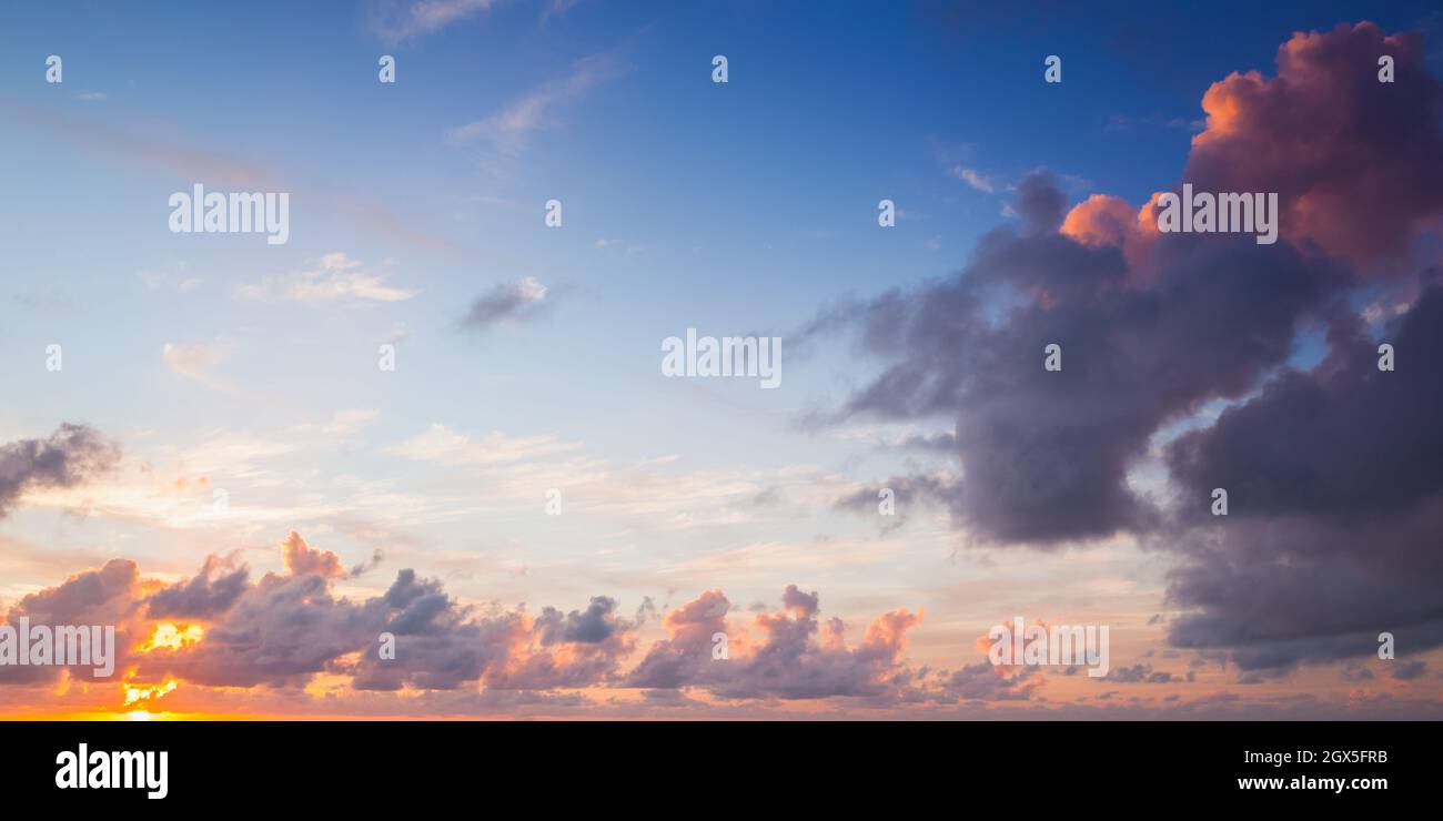 Bunte Wolken an einem Sommermorgen, Panorama-Hintergrundfoto des hellen tropischen Himmels Stockfoto
