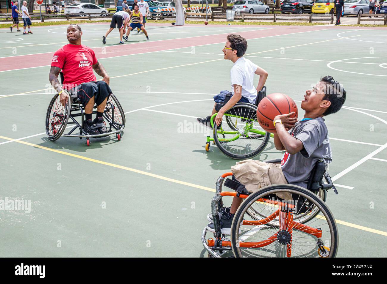 Miami Florida, Tropical Park, Paralympische Erfahrung, Sport spielen aktiv behinderten Basketballplatz Rollstuhl, schwarz asiatischen Jungen Schießen Körbe Männer männlich Stockfoto