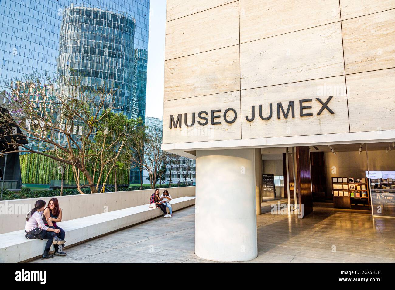 Mexiko-Stadt, hispanisch mexikanisch, Museo de Arte Moderno Jumex Art Museum Mädchen, weiblich, Teenager Teenager Teenager Freunde sitzen vor dem Eingang reden Stockfoto