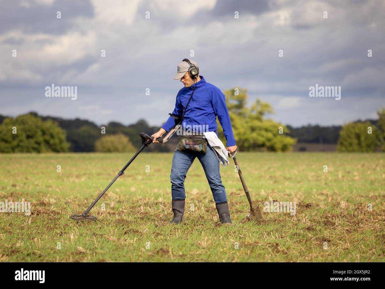 Schatzsucher mit einem Metalldetektor auf einem Feld. Hertfordshire, Großbritannien. Stockfoto