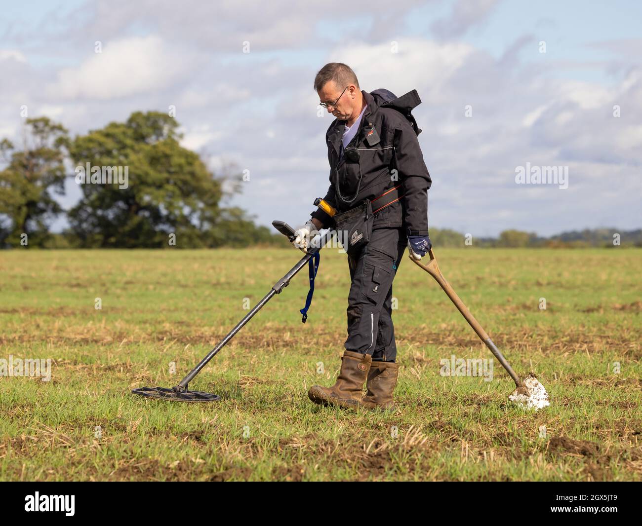 Schatzsucher mit einem Metalldetektor auf einem Feld. Hertfordshire, Großbritannien. Stockfoto