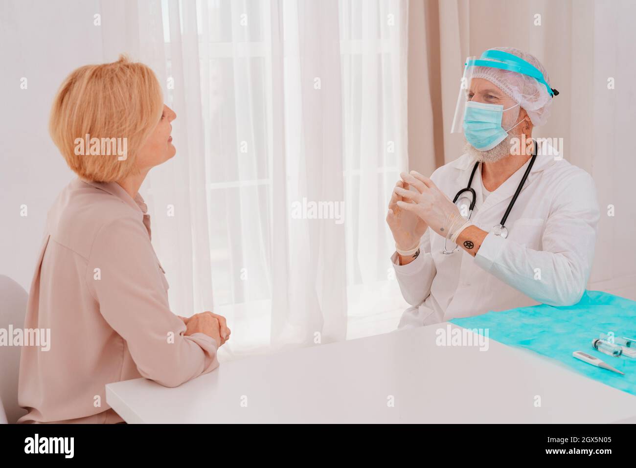 Der Arzt erklärt dem Patienten Informationen über das Covid-19-Virus Stockfoto