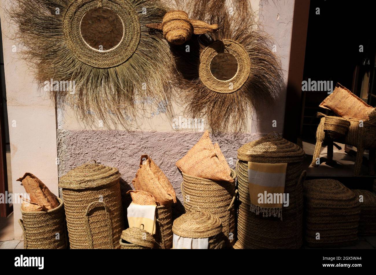 Korbarbeiten und Textilien zum Verkauf in Geschäften in der kleinen Stadt Arta, Mallorca. Körbe und Beutel werden durch Flechten von Palmblättern hergestellt. Stockfoto