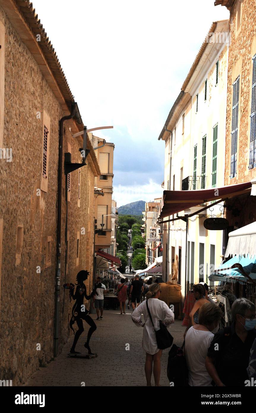 Eine schmale Straße in der Stadt Artá, Mallorca. Die Stadt zieht viele Touristen an, einige werden von den einheimischen Korbflechtungen mit getrockneten Palmblättern angezogen. Stockfoto