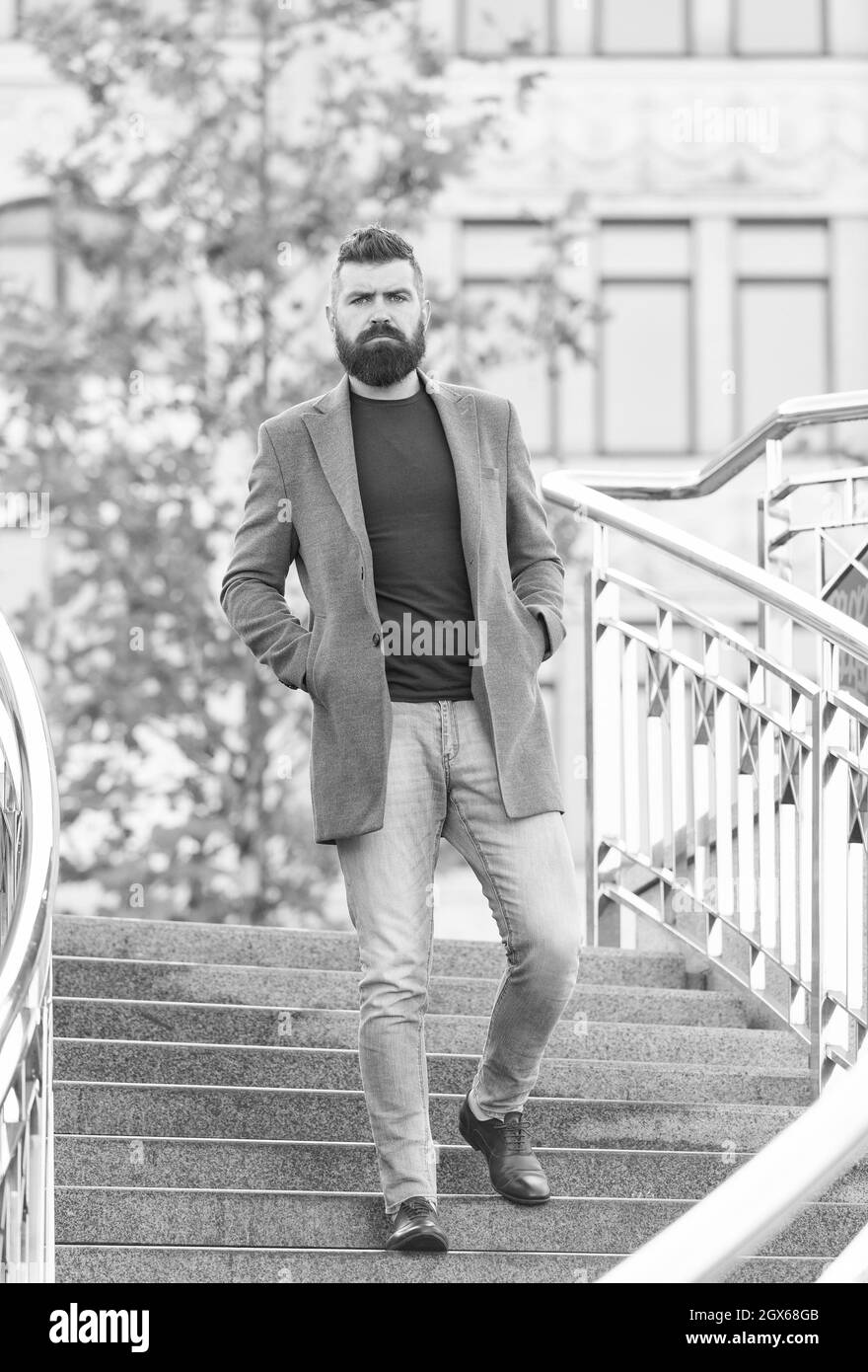 Selbstbewusster männlicher Geschäftsmann in legerer Business-Mode-Jacke gehen in der Straße mit gepflegtem Bart und Frisur, modernes Leben Stockfoto
