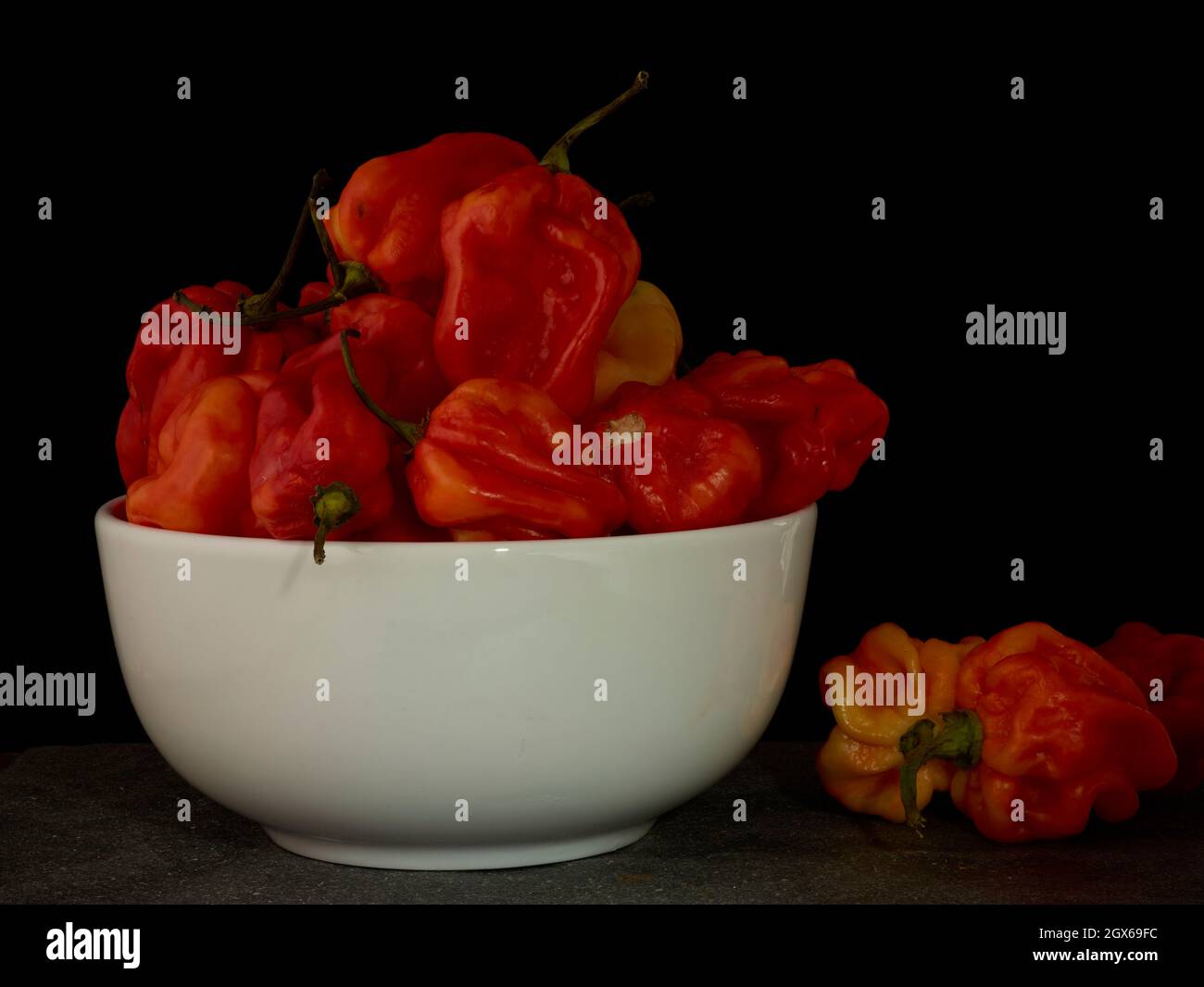 Die Stillleben von Scotch Bonnet Peppers mit hochauflösenden Lebensmittelzutaten auf einem einfachen Hintergrund Stockfoto