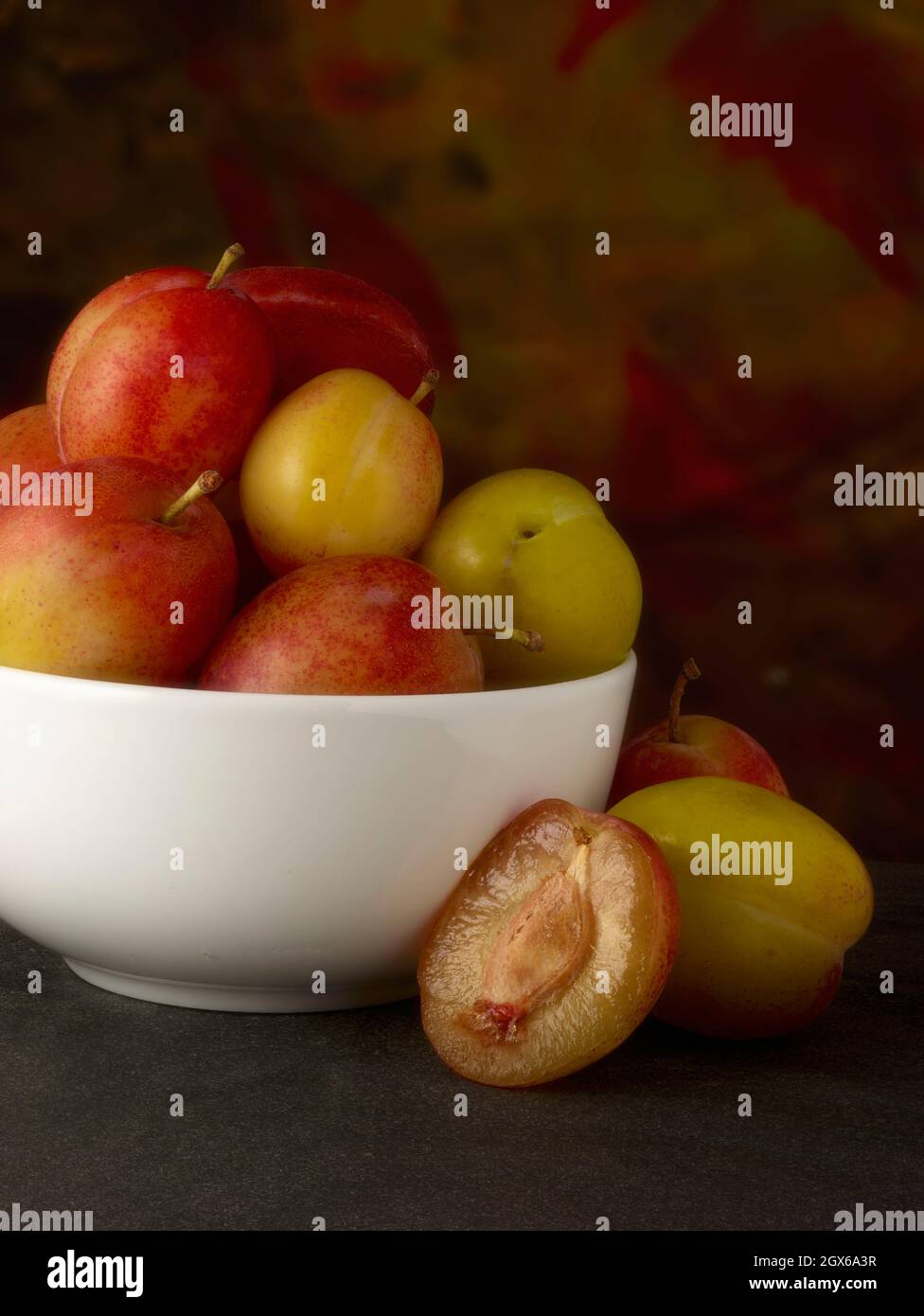 Markt frische süße Pflaumen, natürliche Nahrung Stillleben vor einfachem Hintergrund Stockfoto