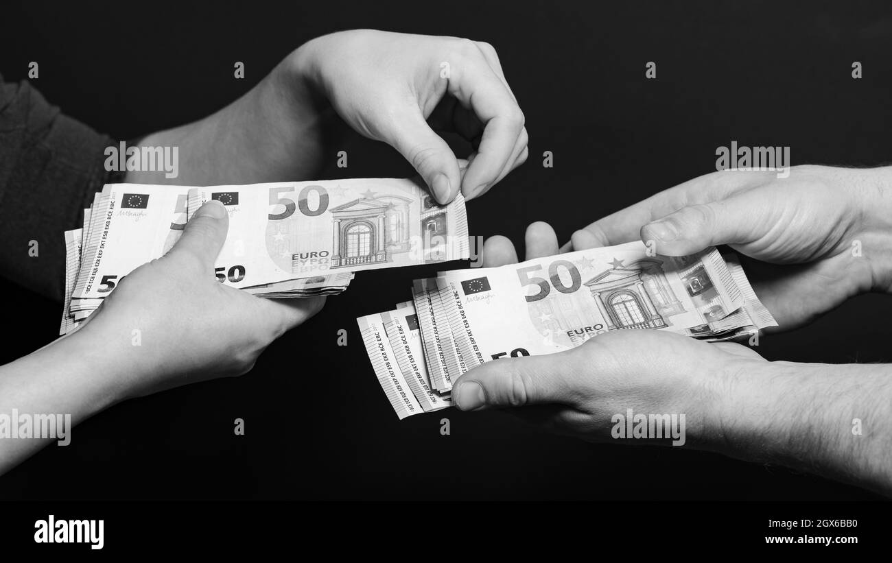 Die Menschen zählen Geld, Euro-Rechnungen von Mann und Frau, Geld auf  schwarzem Hintergrund. Neu Stockfotografie - Alamy
