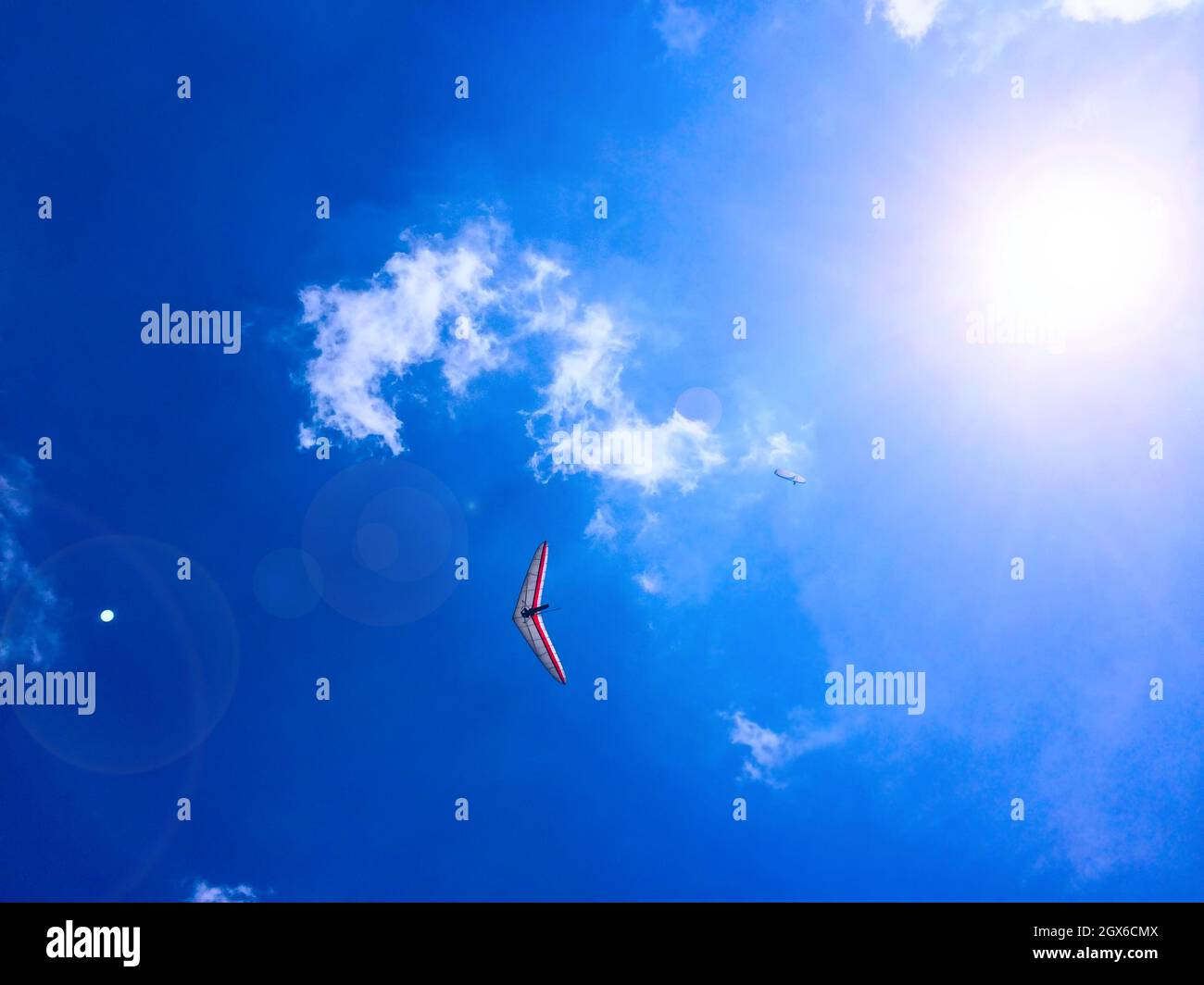 Gleitschirm und Drachenflieger am blauen Himmel mit Wolken Stockfoto