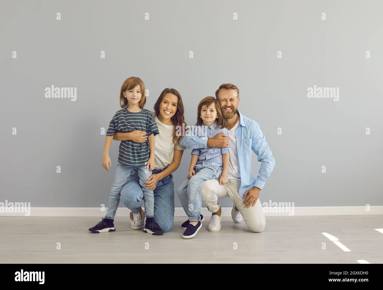 Porträt von glücklicher Mutter, Vater und Kindern in lässiger Kleidung lächelnd und Blick auf die Kamera Stockfoto