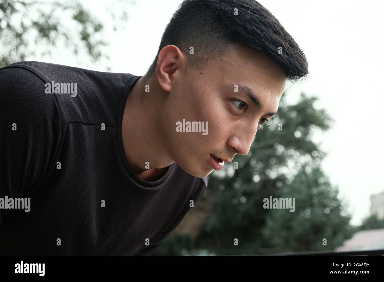 Aufnahme eines hübschen jungen Mannes, der nach einem morgendlichen Lauf in der Stadt einen Moment zum Atmen einnahm Stockfoto