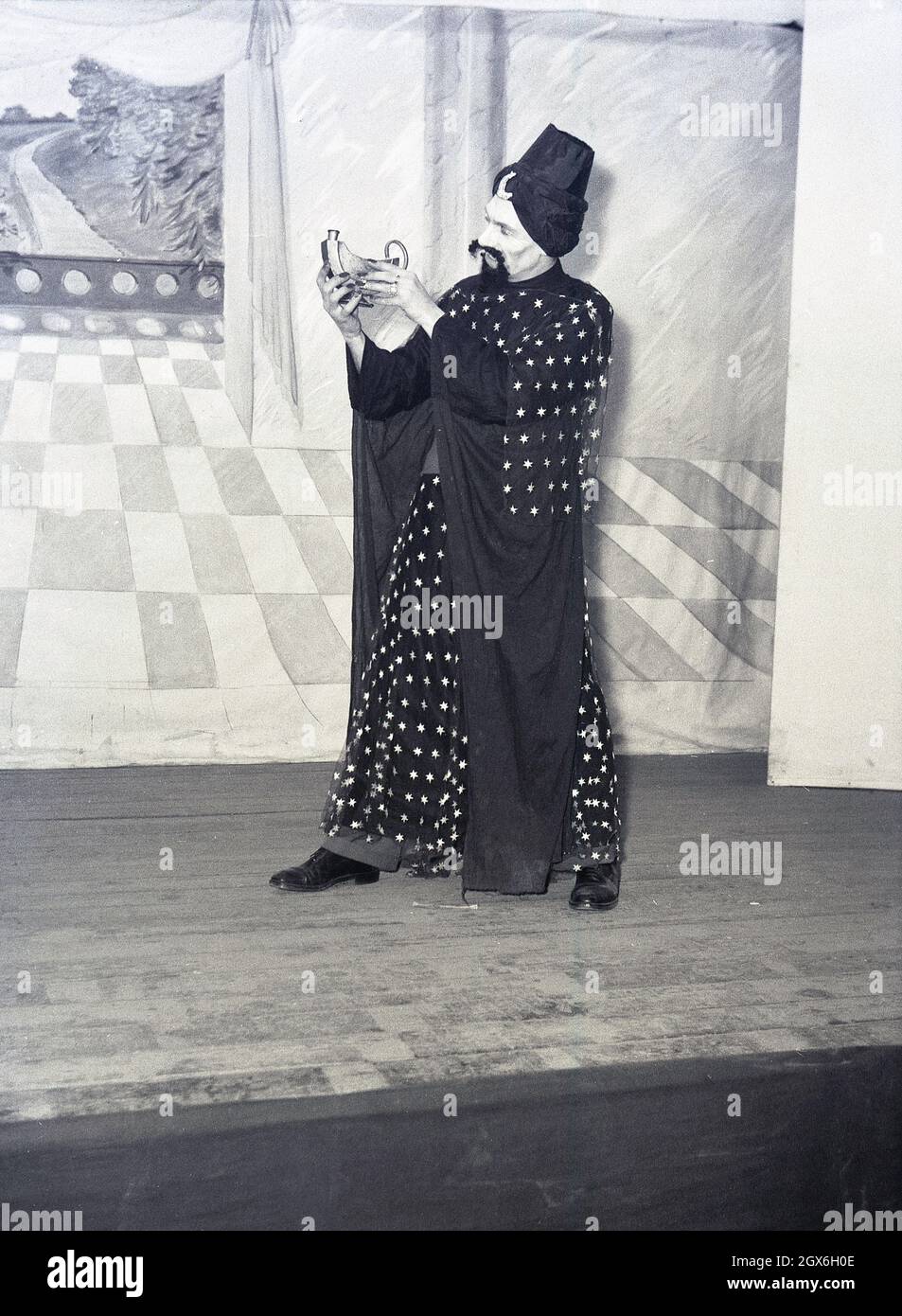 1957, historisch, ein männlicher Schauspieler auf einer Bühne in Kostümen, der den Dschinn oder Genie im Stück Aladdin spielt, basierend auf einer Volksgeschichte aus dem Nahen Osten über den Sohn einer armen Witwe in china, die Besitzer einer magischen Lampe wird, England, Großbritannien. Stockfoto