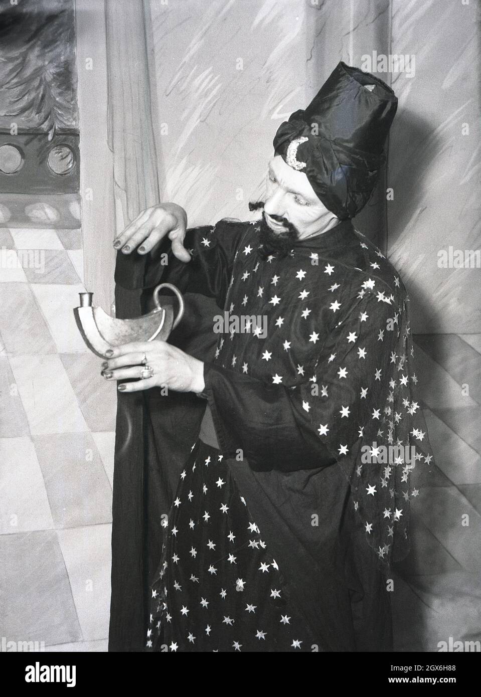 1957, historisch, ein männlicher Schauspieler auf einer Bühne in Kostümen, der den Genie im Stück Aladdin spielt, basierend auf einer Volksgeschichte aus dem Nahen Osten über den Sohn einer armen Witwe in china, die zum Besitzer einer magischen Lampe wird, England, Großbritannien. Stockfoto