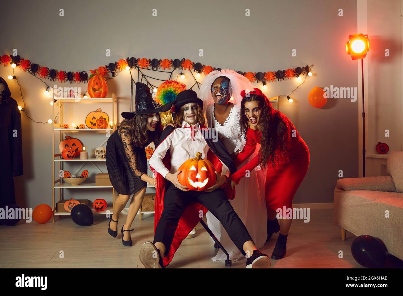 Fröhliche Freunde in gruseligen Kostümen, die an Halloween gemeinsam auf einer verrückten Party Spaß haben Stockfoto