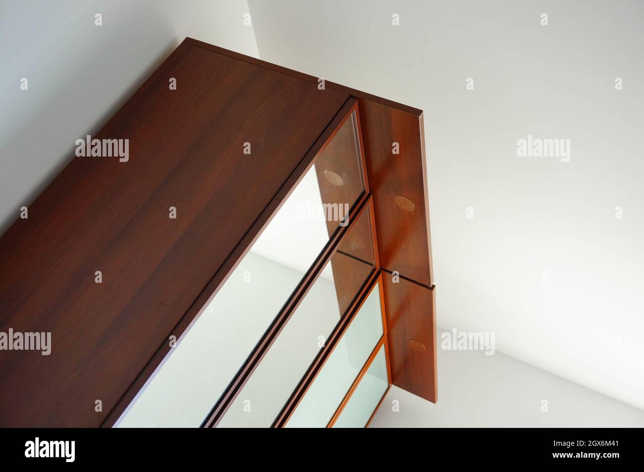 Kleiderschrank mit Spiegel, der an einer Ecke des Zimmers steht Stockfoto