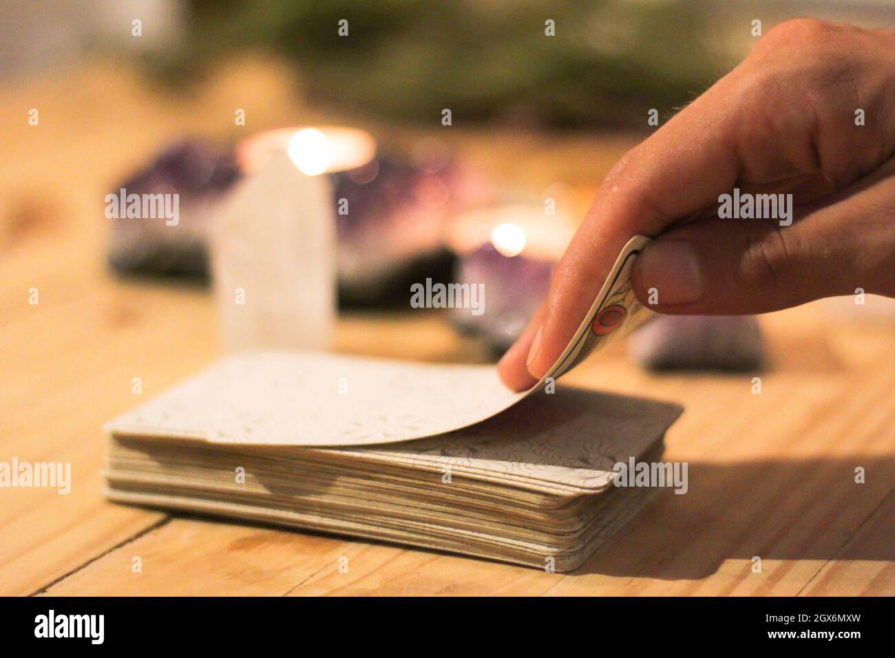 Tarot-Karten, Kerzen und Kristalle mit Tageslicht. Konzept der esoterischen mit spirituellen Symbolen. Magie und Weissagung. Stockfoto