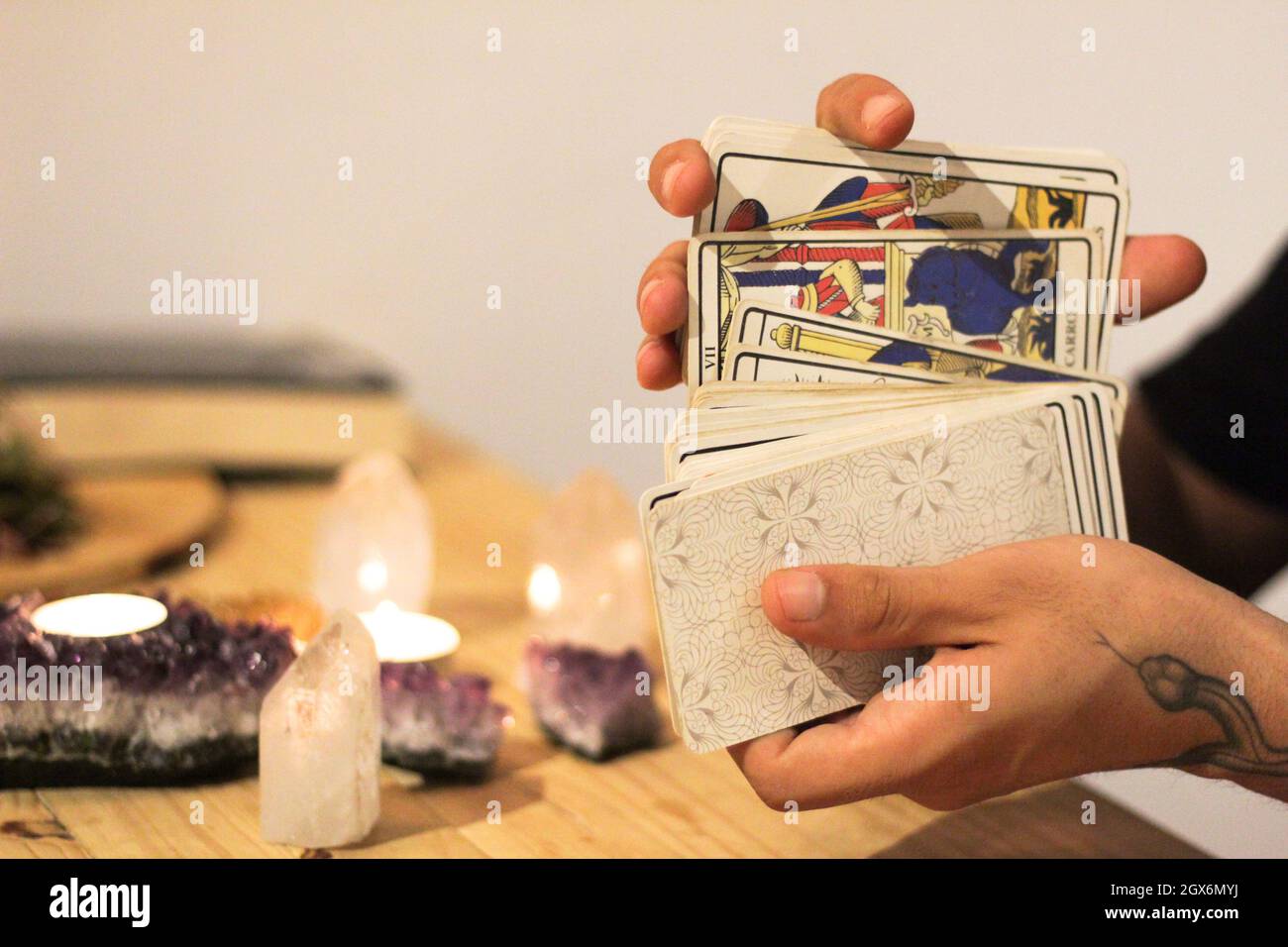 Tarot-Karten, Kerzen und Kristalle mit Tageslicht. Konzept der esoterischen mit spirituellen Symbolen. Magie und Weissagung. Stockfoto
