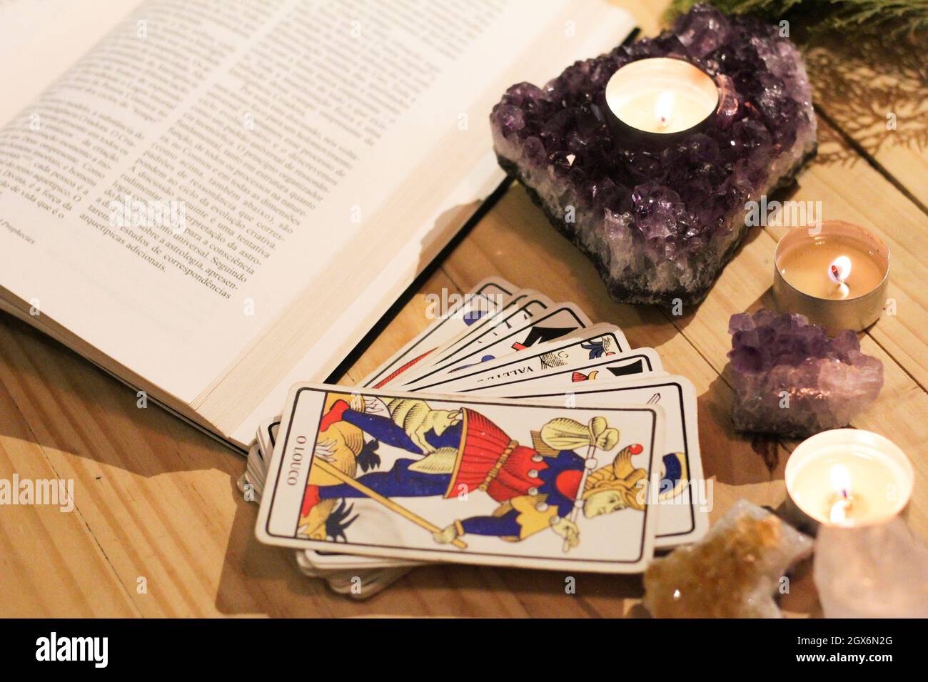 Tarot-Karten, Kerzen und Kristalle mit Tageslicht. Konzept der esoterischen mit spirituellen Symbolen. Magie und Weissagung. Stockfoto