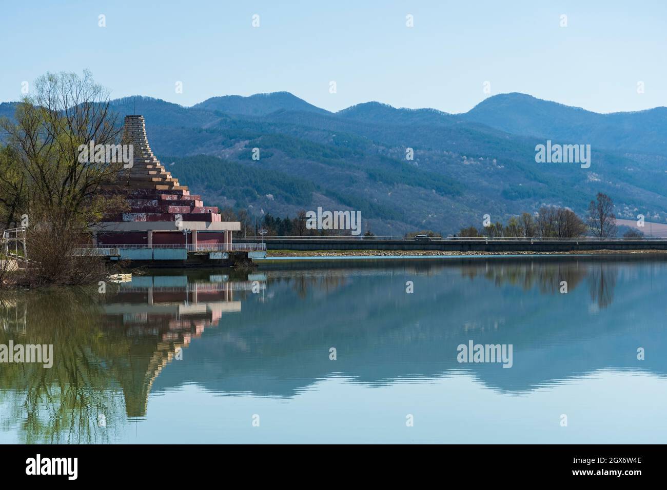 Ein pyramidenähnliches Gebäude an der Küste eines Sees in Bulgarien. Berühmte Attraktion. Berge in der Ferne. Sonniger Tag. Stockfoto