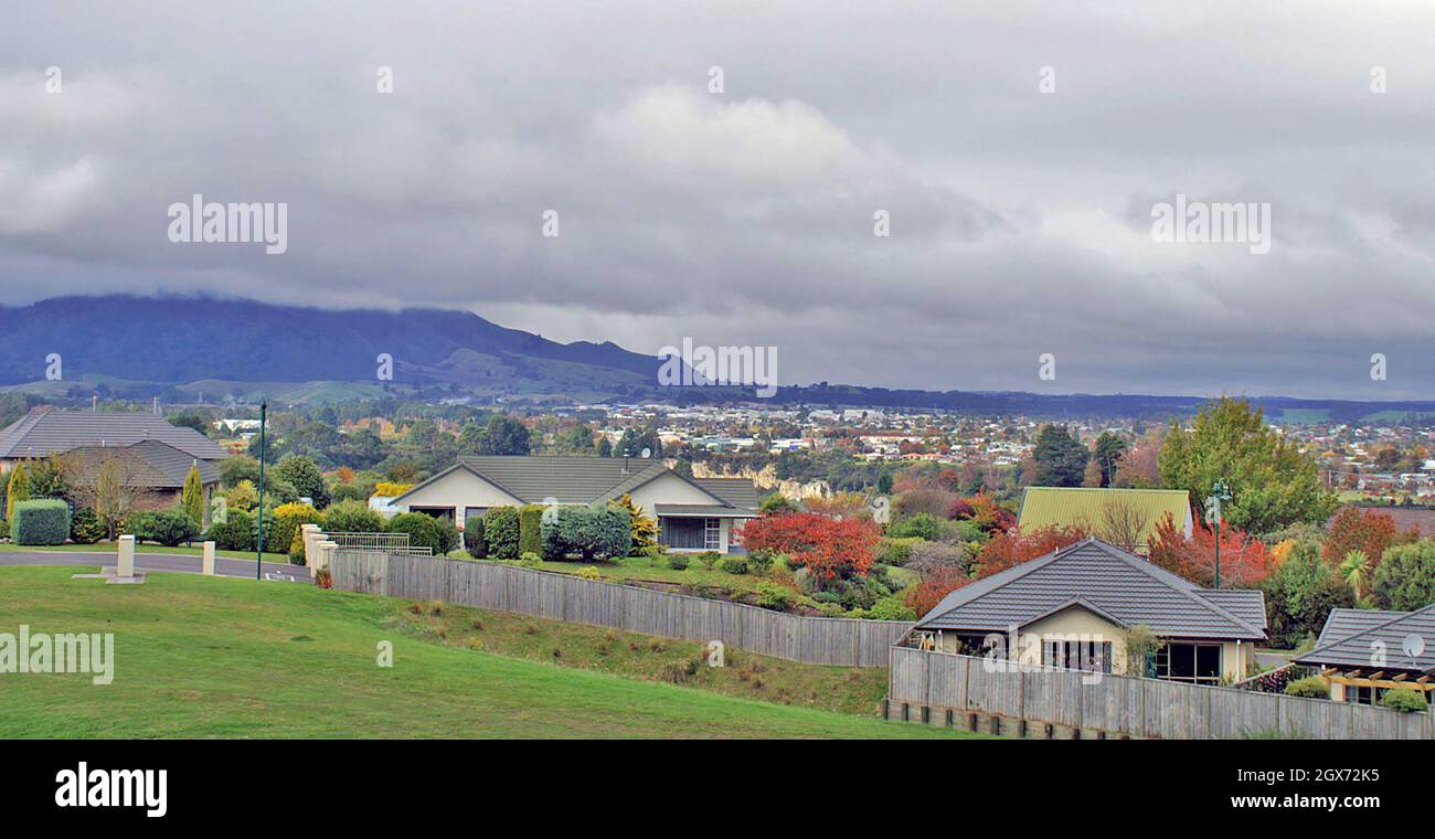 Wohnhäuser in Rotorua, Neuseeland, im April 2005 als bedrohliche Sturmwolken in der Stadt verweilen. Stockfoto
