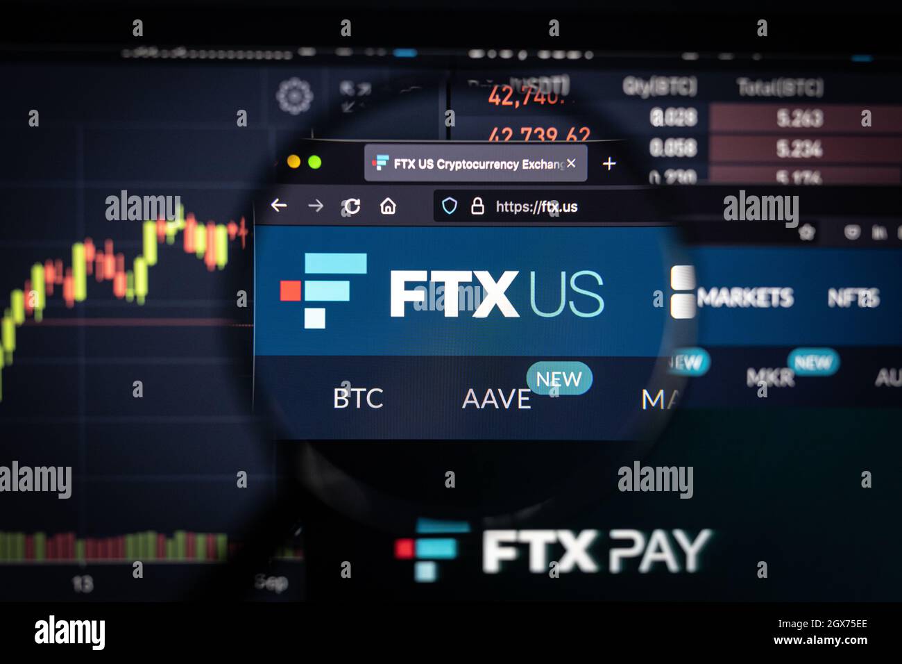 FTX US Kryptowährungsbörse Logo auf einer Website mit verschwommenen Börsenentwicklungen im Hintergrund, auf einem Computerbildschirm gesehen Stockfoto