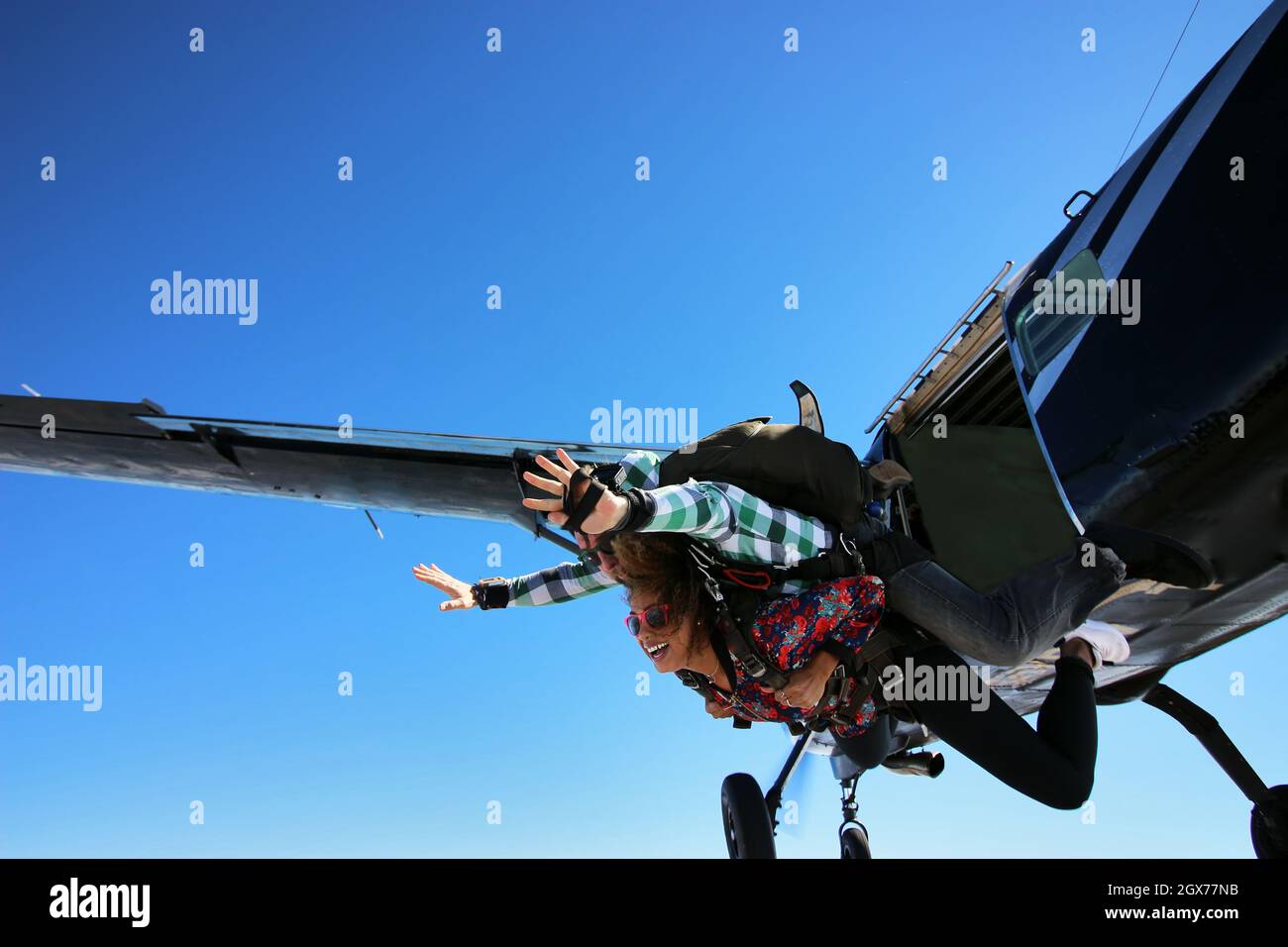 Tandemspringen mit Fallschirm. Schöne brasilianische Frau. Stockfoto