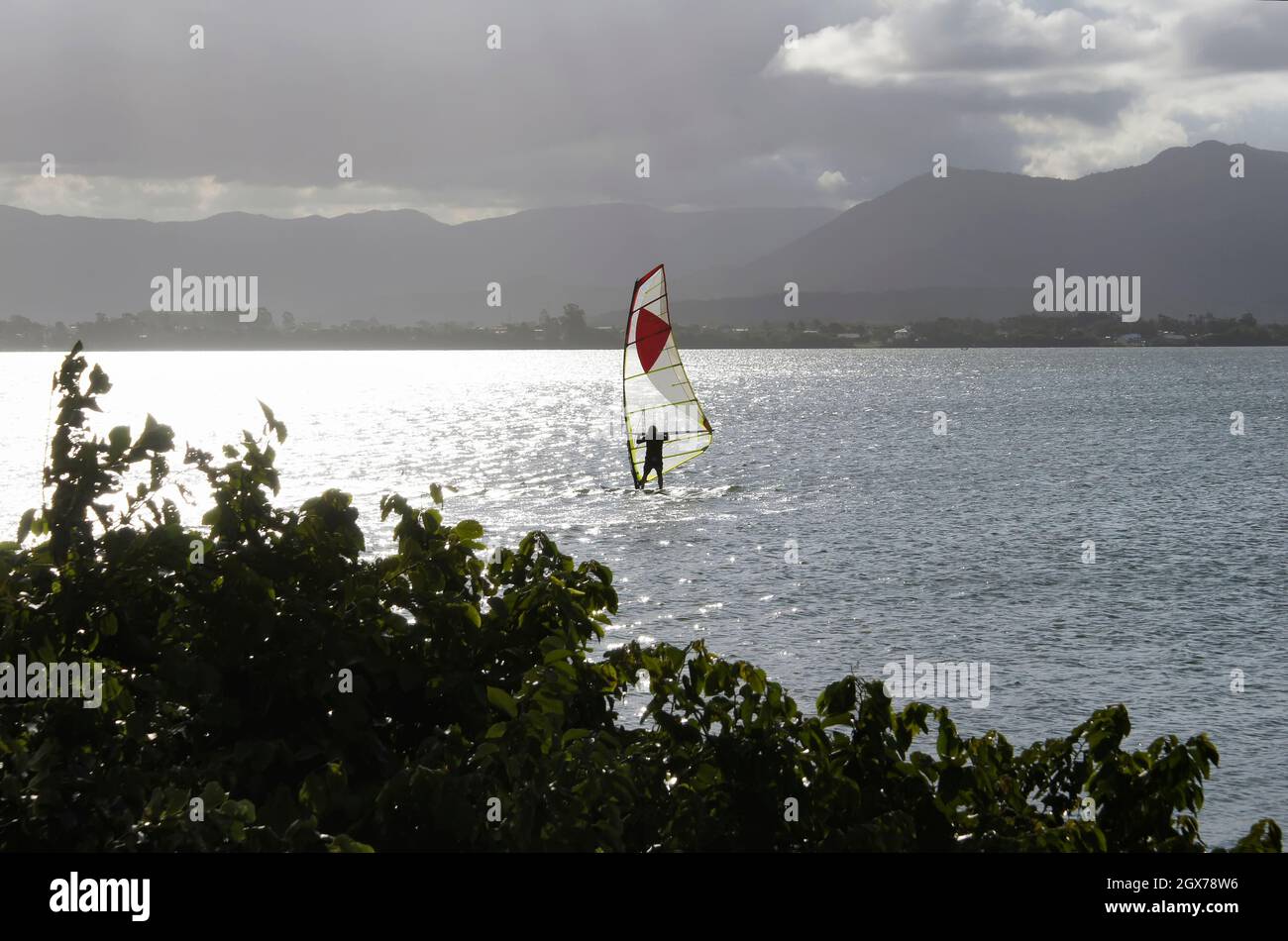 Junge und ältere Menschen üben Kitesurfen und Windsurfen in der Lagune von Ibiraquera. Stockfoto