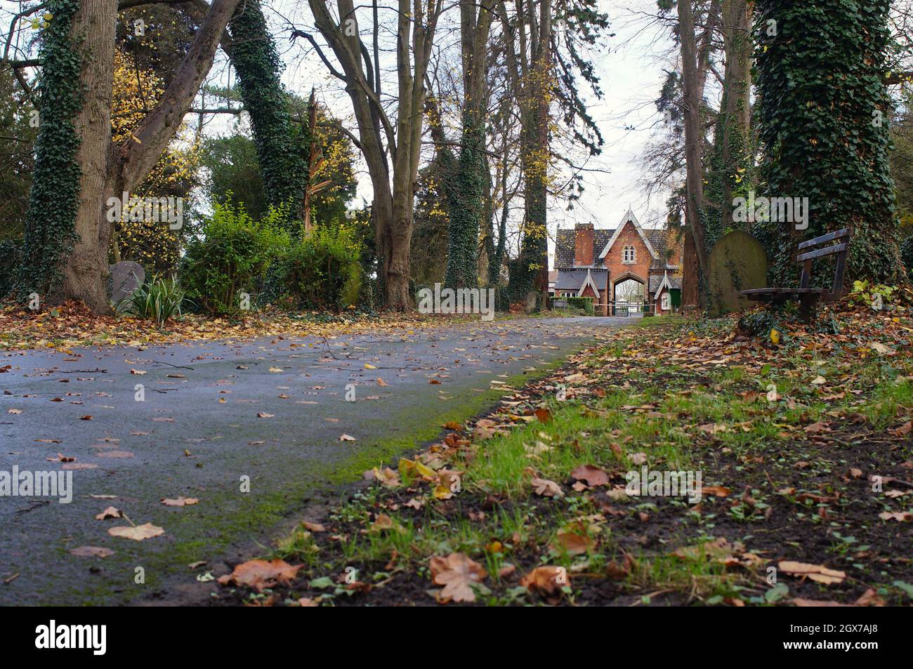 Straße durch den alten viktorianischen Friedhof und den Eingang des Torhauses in der Ferne. Stockfoto