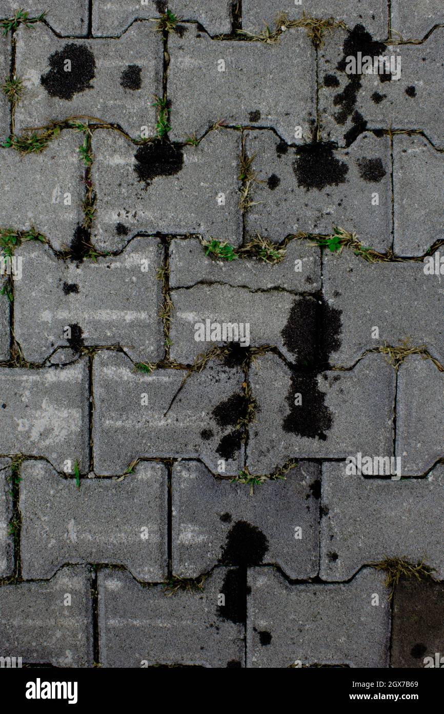 Maschinenölflecken auf grauem Pflaster. Schwer zu reinigder Fleck. Stockfoto