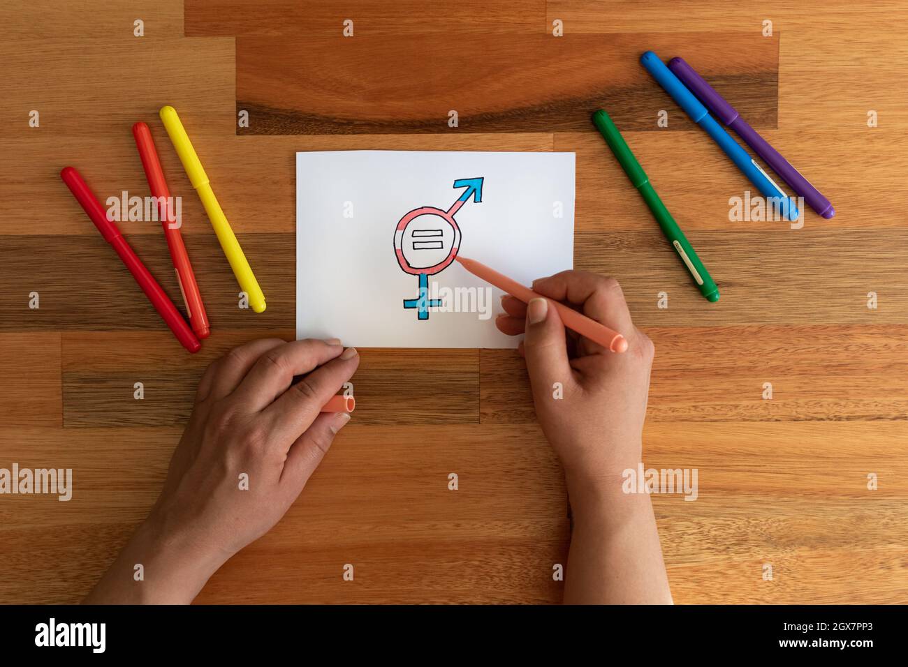 Die Hände der Frau zeichnen ein Symbol, das die Gleichstellung der Geschlechter bei Transgender-Menschen darstellt. Stockfoto