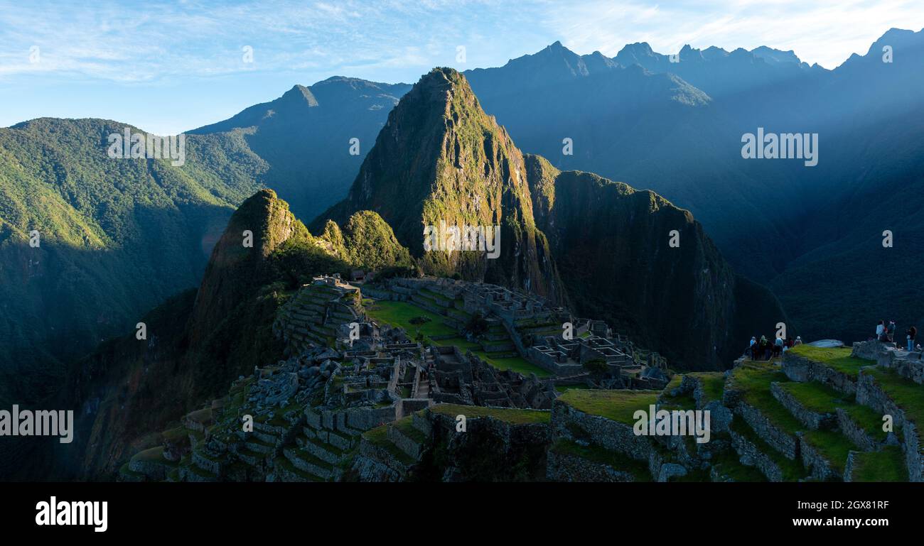 Machu Picchu-Panorama bei Sonnenaufgang mit ersten Sonnenstrahlen, die die inka-Ruine in Peru erleuchten. Stockfoto