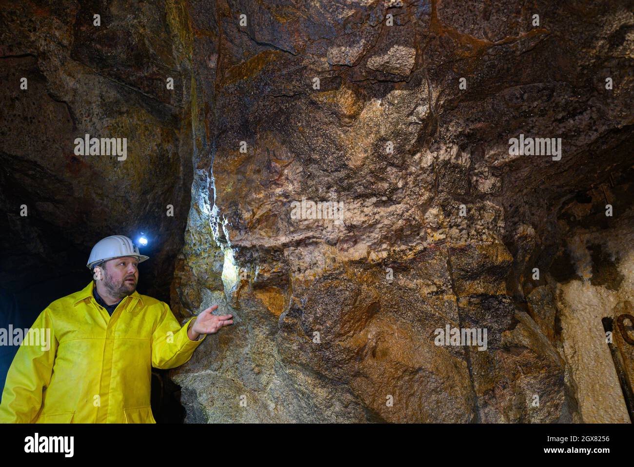 04. Oktober 2021, Sachsen, Zinnwald: Thomas Dittrich, Geologe der Deutschen Lithium GmbH, betrachtet erztragendes Gestein im Besucherbergwerk 'vereinigt Zwitterfeld zu Zinnwald'. Im Zinnwald, unter dem Erzgebirge an der deutsch-tschechischen Grenze, will die Deutsche Lithium GmbH eine Mine und eine Verarbeitungsanlage bauen. Die Lagerstätte wird auf rund 125,000 Tonnen Lithium geschätzt - und gilt laut der Sächsischen Oberbergbaubehörde als eine der größten Lagerstätten in Europa. Die Deutsche Lithium startete das Projekt in Sachsen im Jahr 2010. Foto: Robert Michael/dpa-Zentralbild Stockfoto