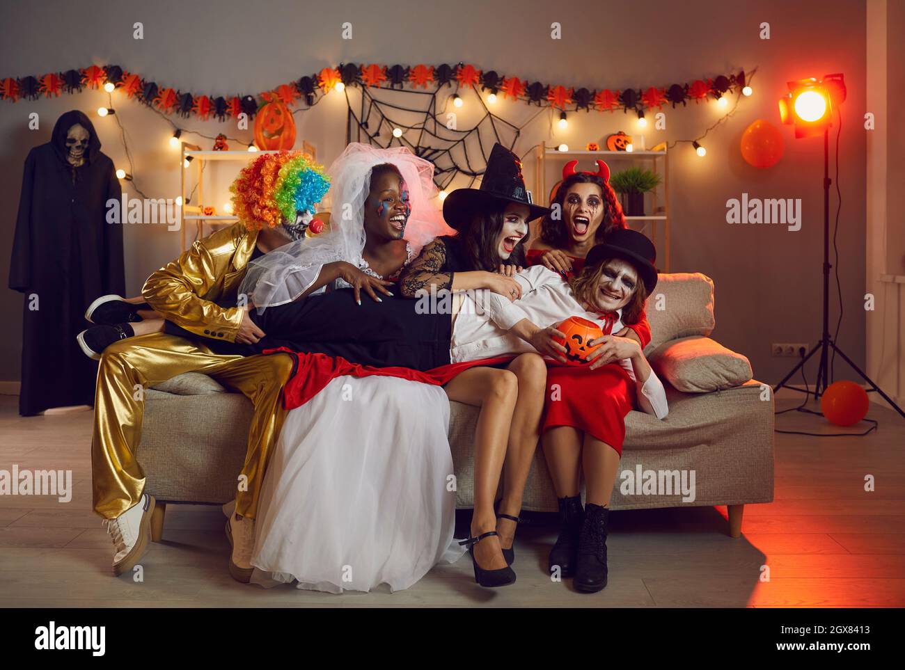 Gruppe von Freunden in gruseligen Kostümen lachen und haben Spaß auf einer Halloween-Party Stockfoto