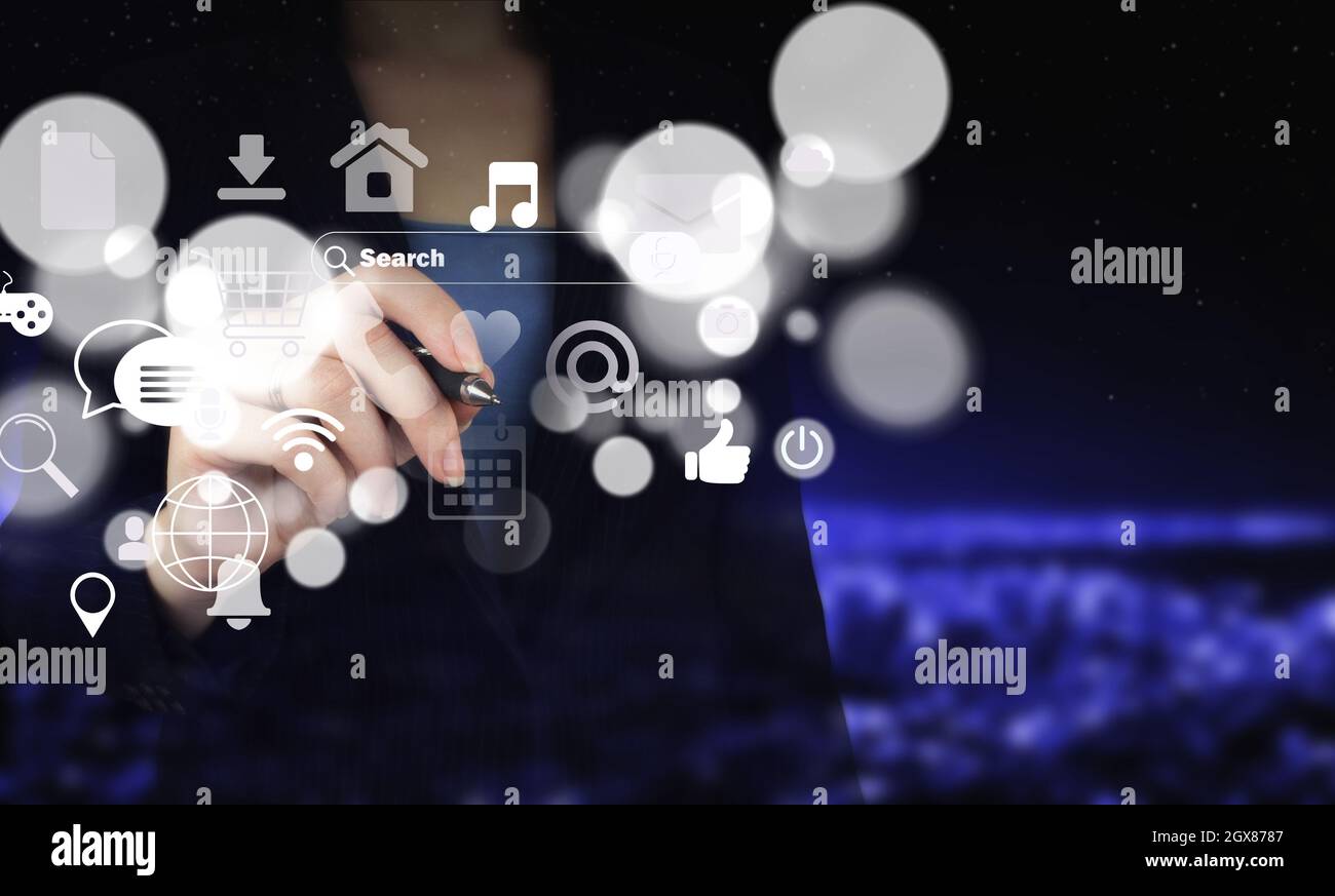 Social-Media-Konzept. Kommunikationsnetzwerk. Hand halten digitalen Grafikstift und Zeichnung digitalen Hologramm Social-Media-Symbole auf Stadt dunkel verschwommen Stockfoto