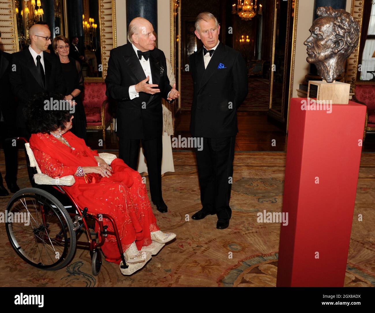 Prinz Charles, Prinz von Wales und die Schauspielerin Dame Elizabeth Taylor sitzen im Rollstuhl und betrachten eine Büste des walisischen Schauspielers Richard Burton während eines Galaabends des Royal Welsh College im Buckingham Palace in London am 29. April 2010. Stockfoto