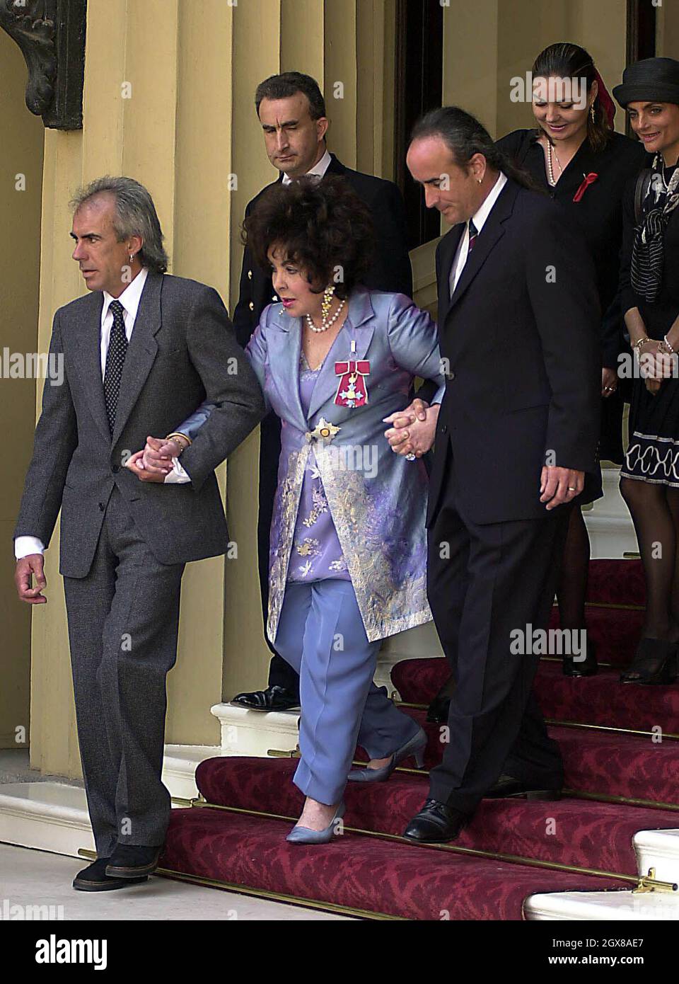 Dame Elizabeth Taylor verlässt in Begleitung ihrer Familie den Buckingham Palace, nachdem sie die Ehre der Kommandantin des britischen Ordens von der britischen Königin Elizabeth II. Bei einer Zeremonie im Buckingham Palace, London, am Dienstag, den 16. Mai 2000, erhalten hat. Stockfoto